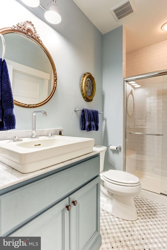 bathroom featuring tile patterned floors, vanity, walk in shower, and toilet