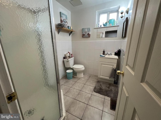 bathroom with tile patterned floors, walk in shower, vanity, tile walls, and toilet