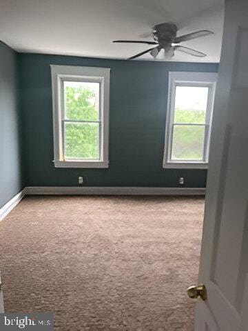 carpeted spare room featuring ceiling fan