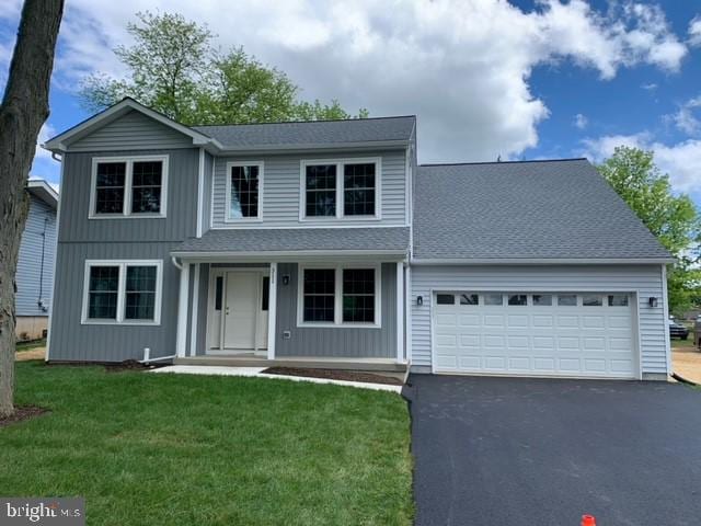 front of property featuring a front yard and a garage