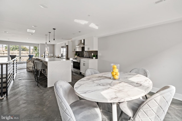 dining area featuring dark parquet flooring and sink