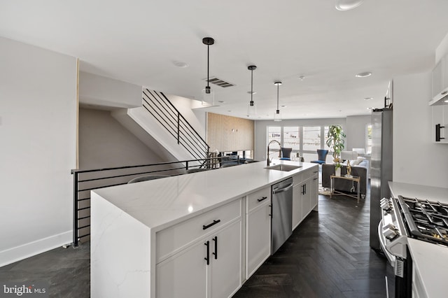 kitchen featuring white cabinetry, a kitchen island with sink, light stone countertops, and stainless steel appliances