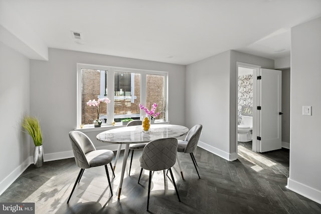 dining area with dark parquet flooring