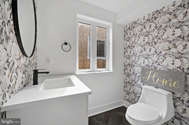 bathroom with parquet flooring, vanity, and toilet