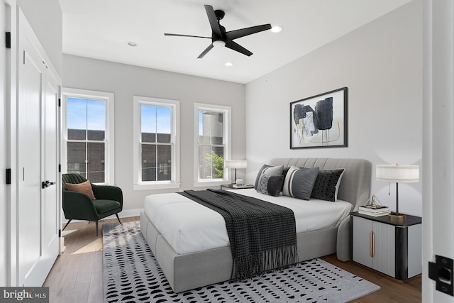 bedroom with dark hardwood / wood-style flooring and ceiling fan