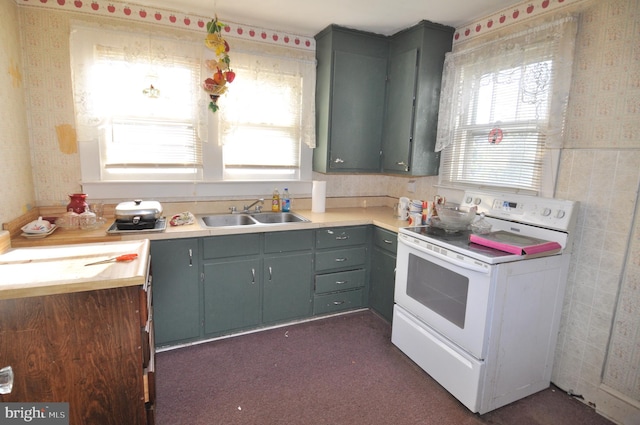 kitchen featuring sink, white range with electric stovetop, and dark colored carpet