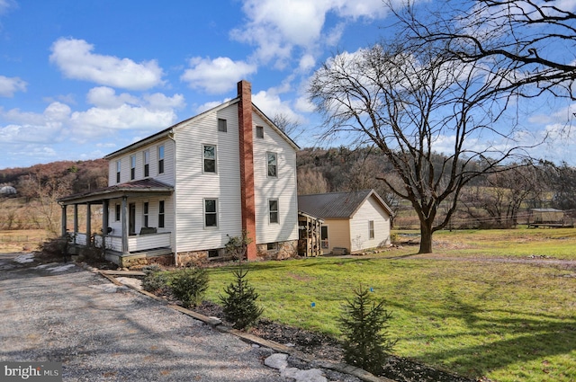 view of side of property with a porch and a yard