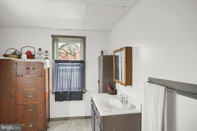 bathroom featuring vanity and a drop ceiling