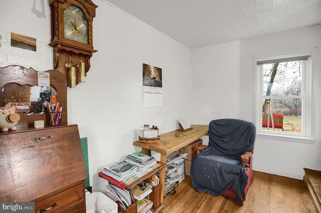 office space with light hardwood / wood-style floors and brick wall