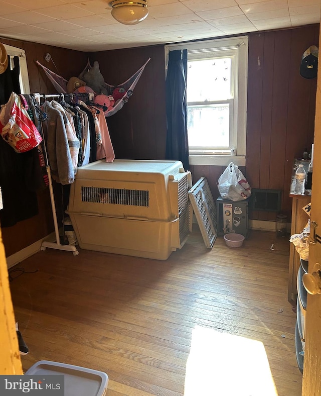 bedroom with wood walls and light hardwood / wood-style flooring