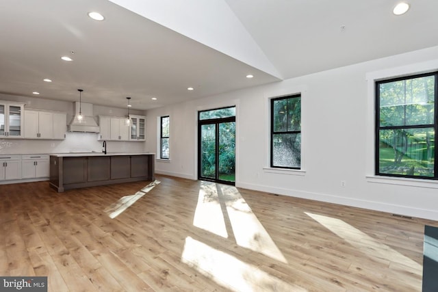 unfurnished living room featuring light hardwood / wood-style floors and lofted ceiling