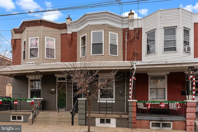 townhome / multi-family property featuring covered porch