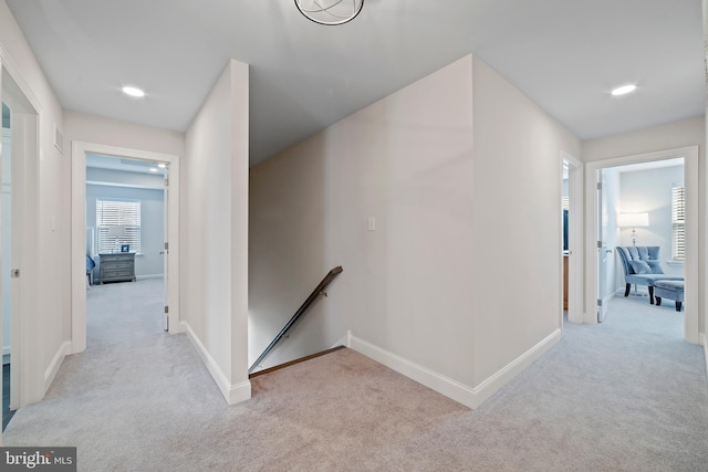 hallway featuring light colored carpet