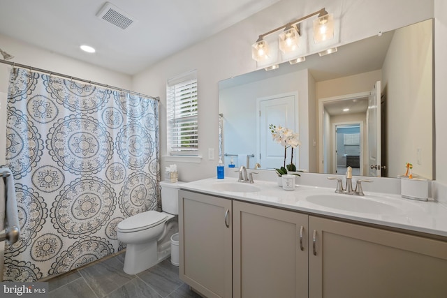 bathroom featuring tile patterned flooring, vanity, and toilet