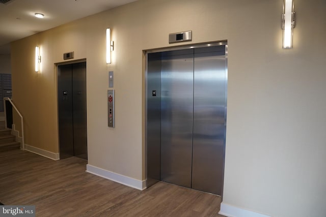 hall with elevator and dark wood-type flooring