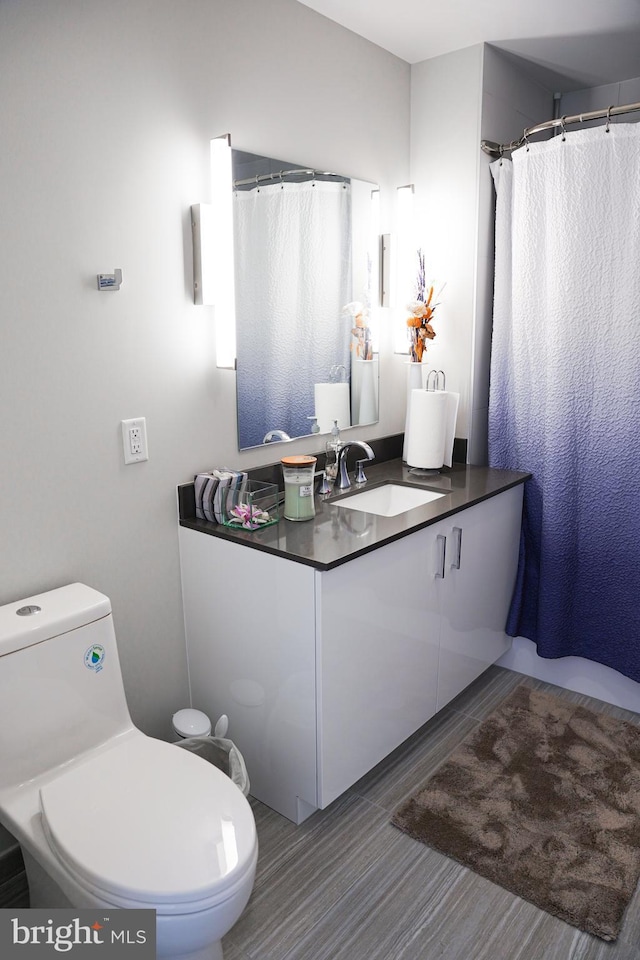 bathroom with hardwood / wood-style floors, vanity, and toilet