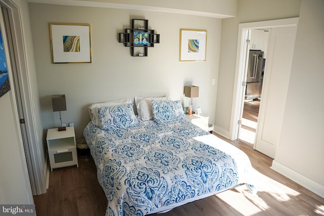 bedroom with wood-type flooring and high end fridge