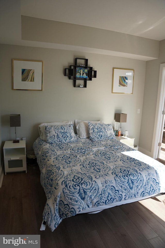 bedroom with dark hardwood / wood-style flooring