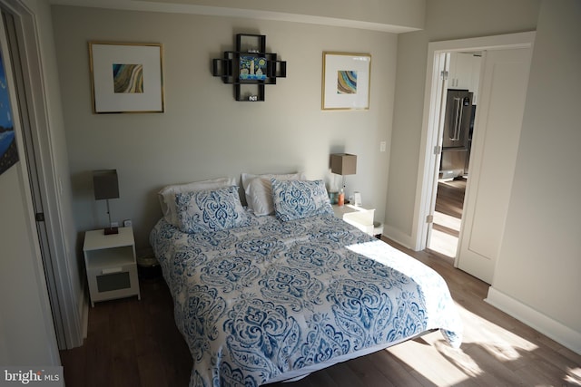 bedroom featuring dark hardwood / wood-style flooring and stainless steel refrigerator