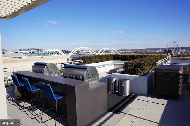 view of patio with grilling area, exterior bar, and an outdoor kitchen