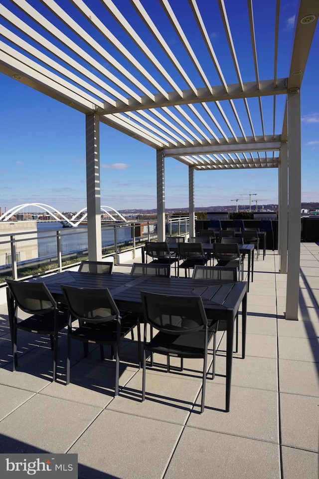 view of patio featuring a pergola and a water view