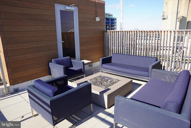 view of patio featuring a balcony and an outdoor living space with a fire pit