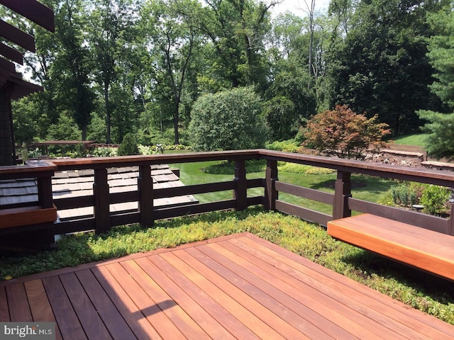 wooden deck featuring a lawn