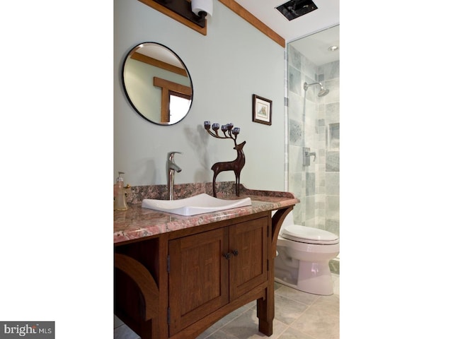 bathroom with tile patterned flooring, toilet, vanity, and tiled shower