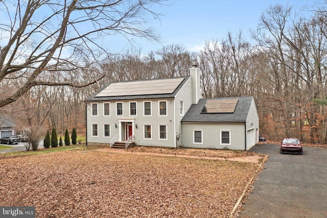 view of front of home with a garage and solar panels