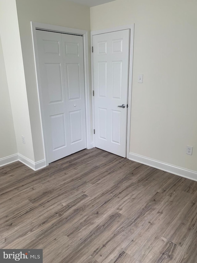 unfurnished bedroom with wood-type flooring and a closet