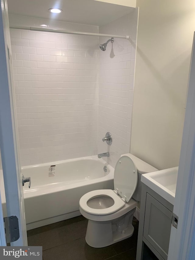 full bathroom featuring tile patterned floors, vanity, tiled shower / bath, and toilet