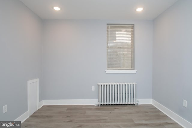 unfurnished room with light wood-type flooring and radiator heating unit