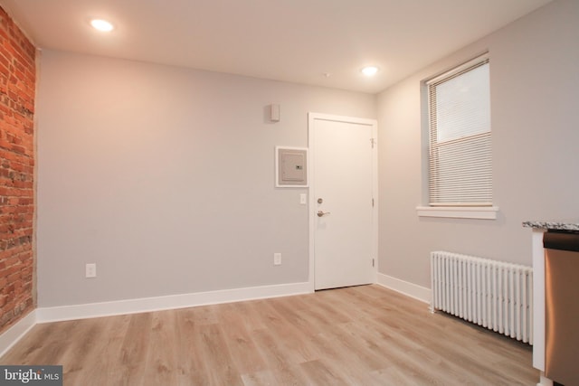 interior space with radiator and light hardwood / wood-style flooring