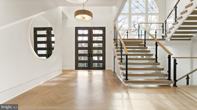 entrance foyer featuring light parquet floors and french doors