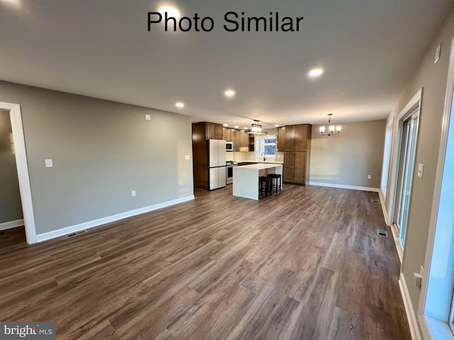 unfurnished living room featuring a chandelier and dark hardwood / wood-style flooring