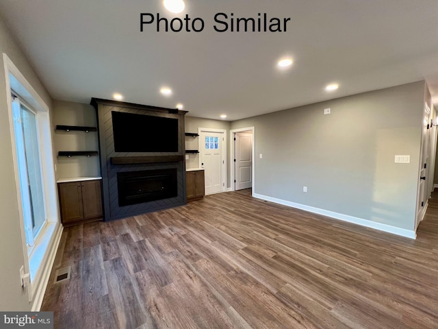 unfurnished living room with hardwood / wood-style floors and a large fireplace