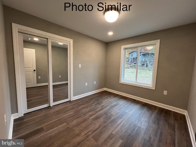 unfurnished room with dark hardwood / wood-style flooring