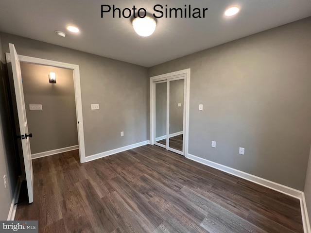 unfurnished bedroom with a closet and dark hardwood / wood-style flooring