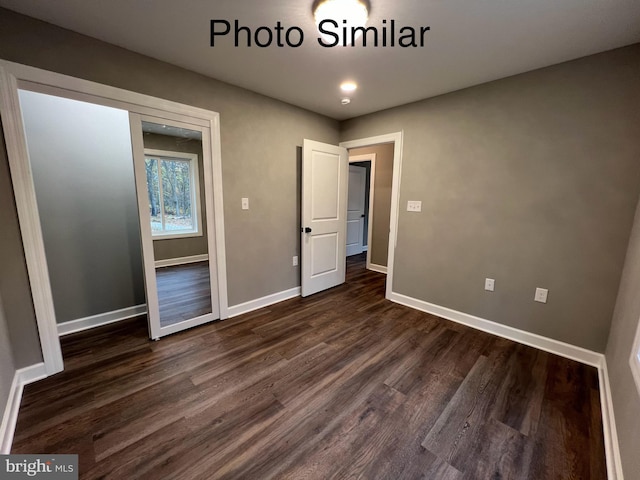 unfurnished bedroom with dark hardwood / wood-style flooring