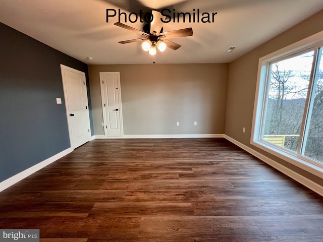 empty room with ceiling fan and dark hardwood / wood-style flooring