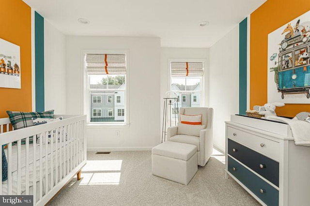 carpeted bedroom featuring a nursery area