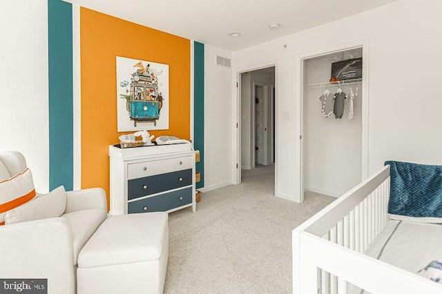 carpeted bedroom with a crib and a closet