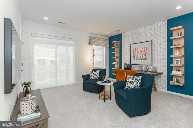 sitting room with carpet flooring and brick wall