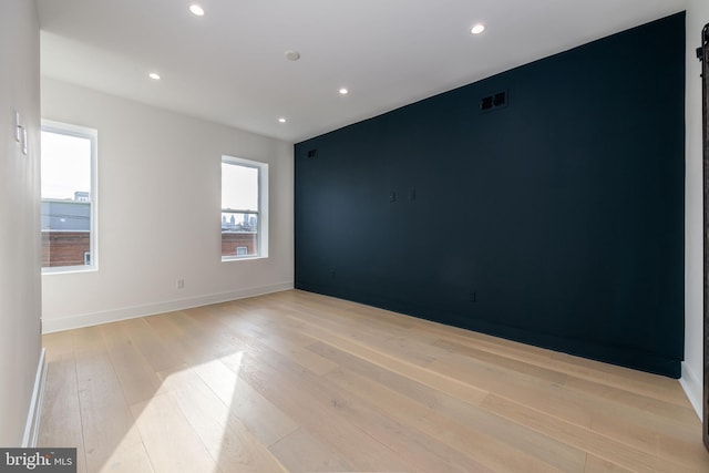 unfurnished room featuring plenty of natural light and light hardwood / wood-style flooring