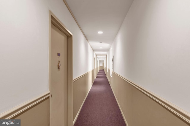 hall featuring dark colored carpet