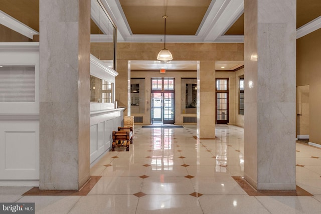 foyer entrance with decorative columns, a high ceiling, light tile patterned floors, and ornamental molding