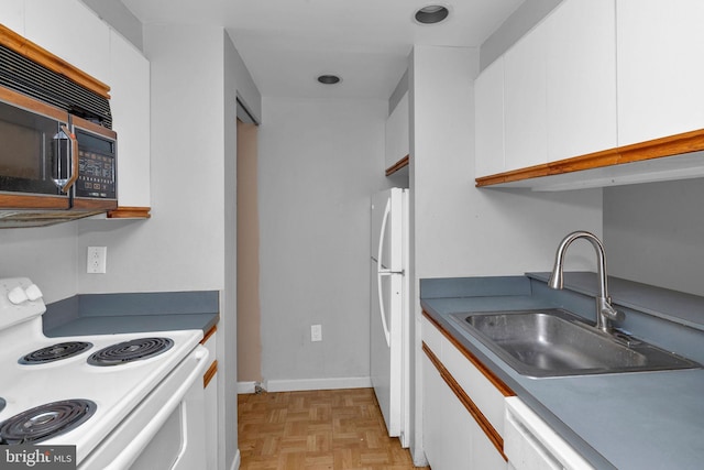 kitchen with light parquet floors, white cabinetry, sink, and white appliances