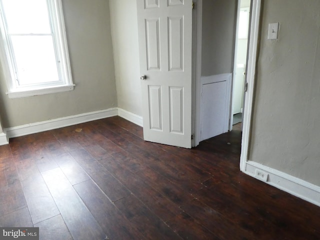 unfurnished bedroom featuring dark wood-type flooring