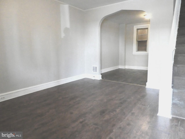 empty room featuring dark hardwood / wood-style floors and crown molding