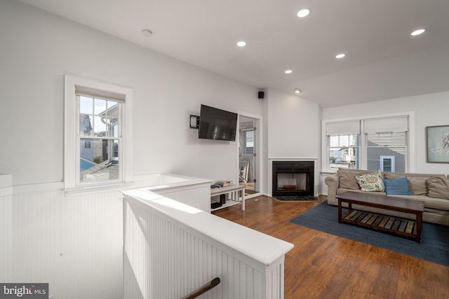 living room with a wealth of natural light and dark wood-type flooring